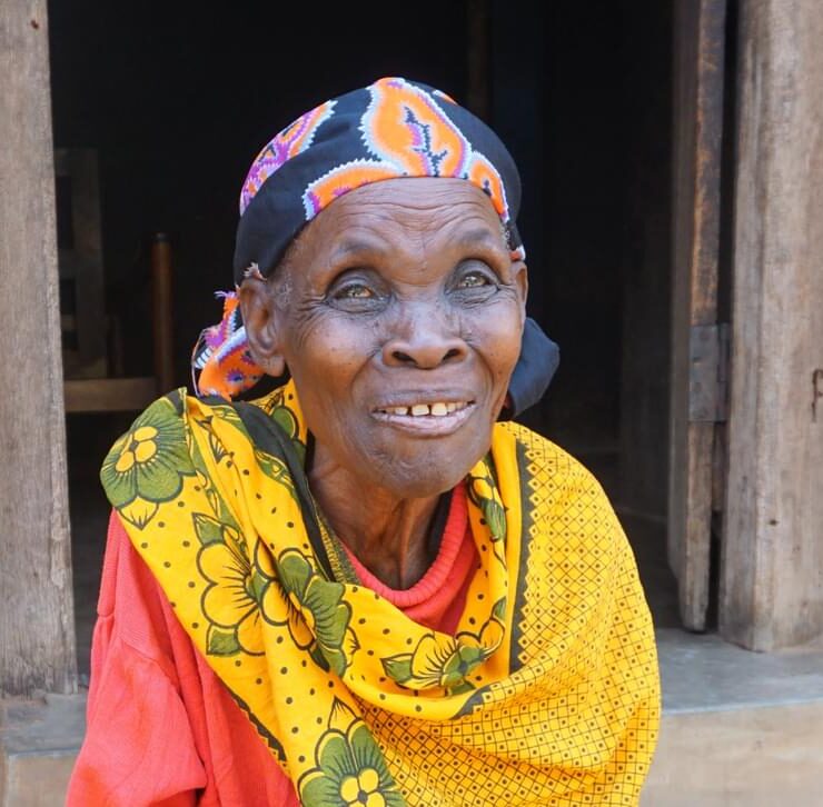 Teodosia smiles at the camera. She received eye care as part of a Peek-powered programme in Tanzania.