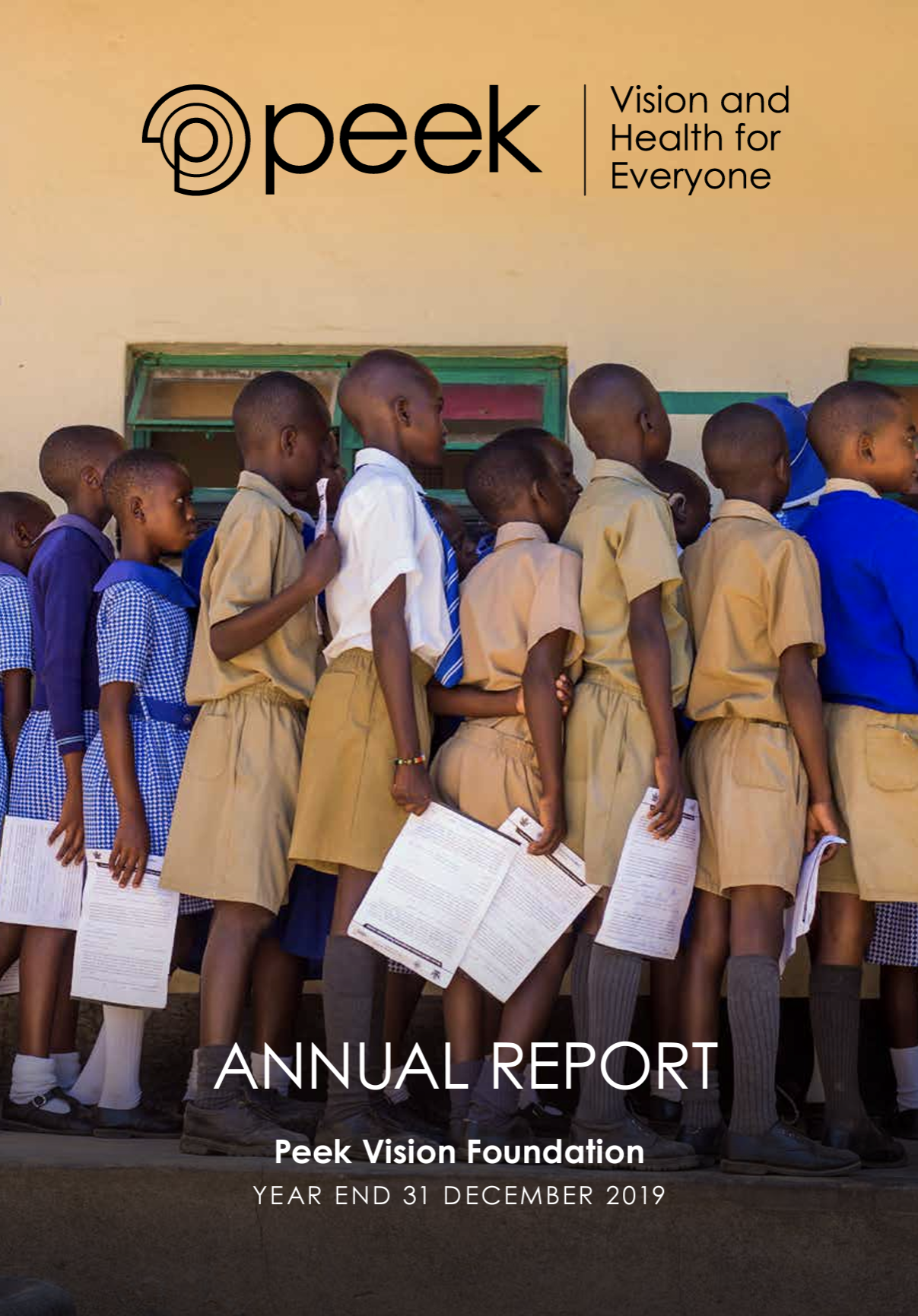 A group of children queue up holding slips of paper as they await their eye test. In front of them the text reads "Peek: Vision and Health for Everyone. Annual Report and Accounts 2019"