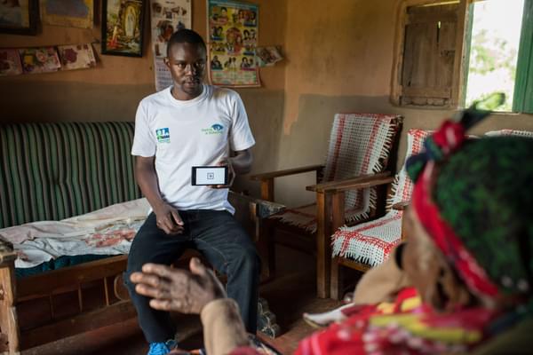 A Peek team member uses Peek's smartphone-based vision check app to check a woman's vision in a house of a remote village of Kitale province, Kenya.