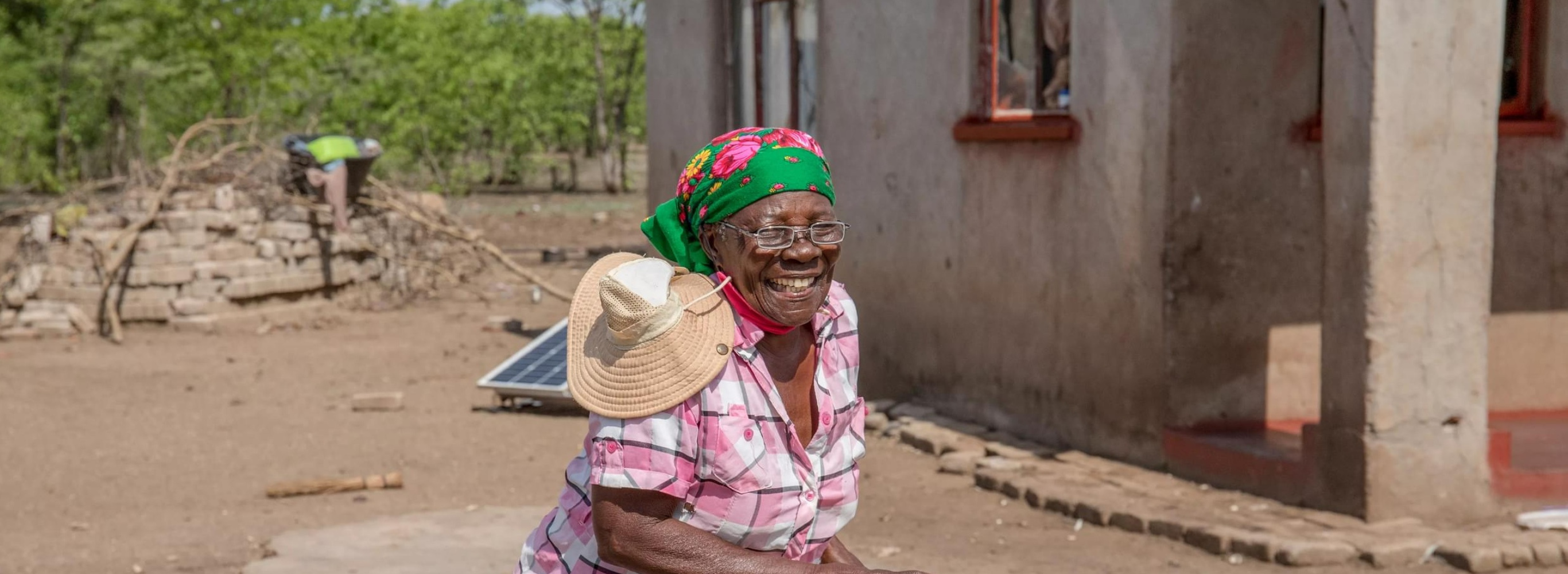 A woman dances and smiles in her rural Zimbabwean village as she celebrates getting a new pair of glasses.
