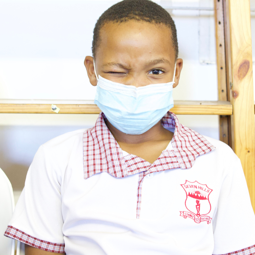 A boy winks as he waits for his vision to be screened as part of a rapid assessment pilot study. He is wearing a facemask as it was during the COVID-19 pandemic.