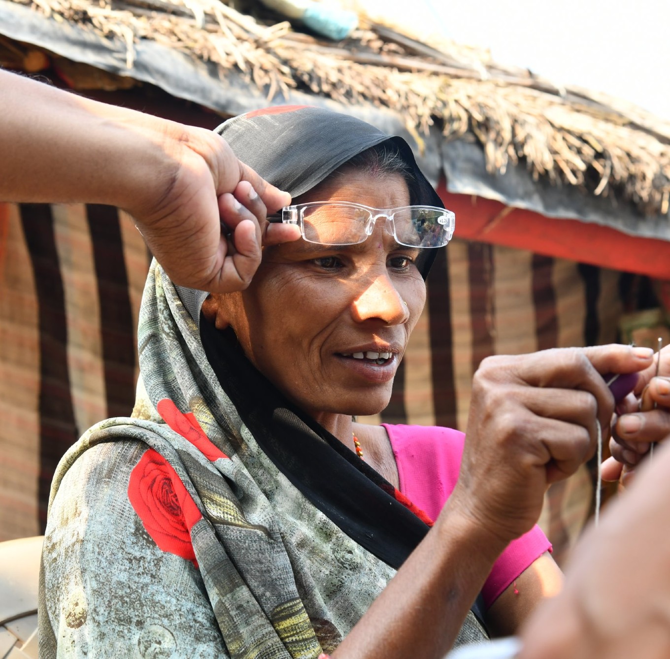 Woman threading a needle