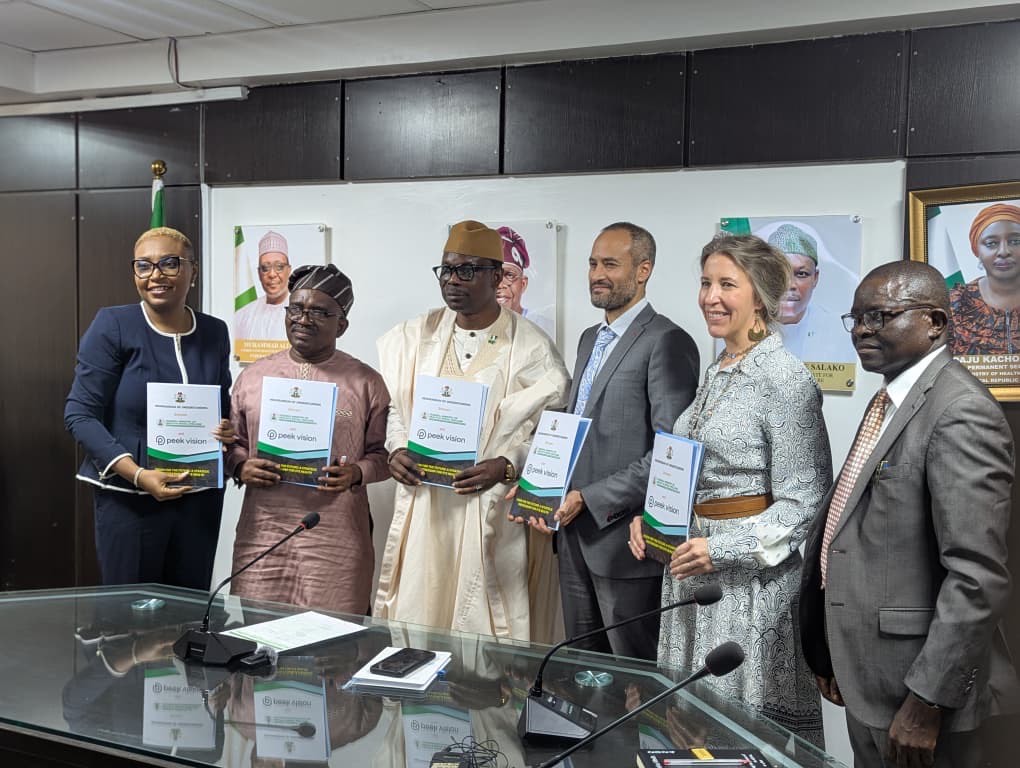 Representatives from Peek Vision and Nigeria's Federal Ministry of Health and Social Welfare pose together holding copies of the MoU document at the signing event.